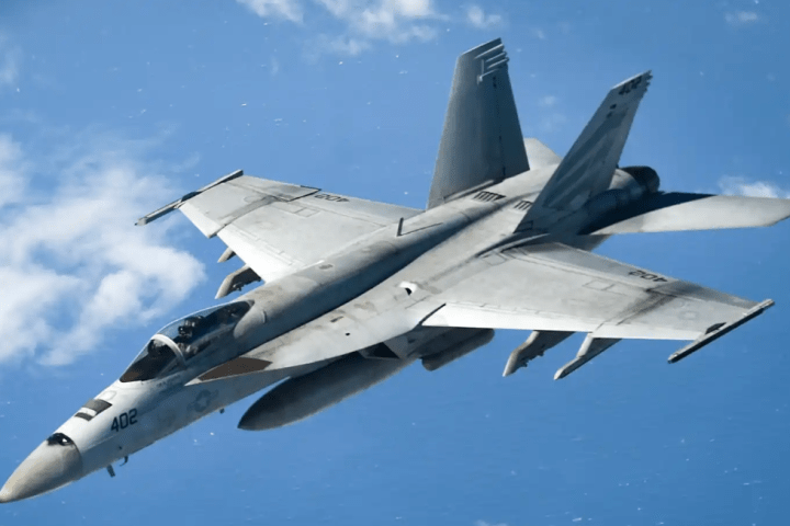 a fighter jet flying through a blue sky