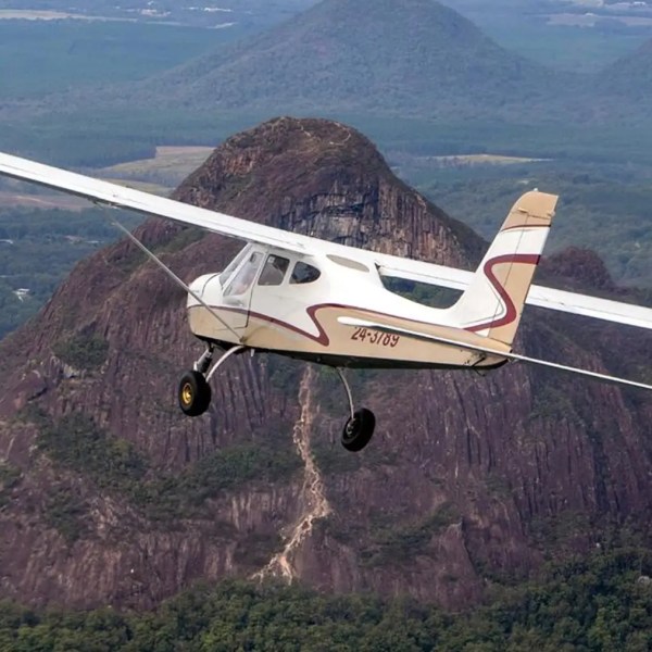 a small airplane with a mountain in the background